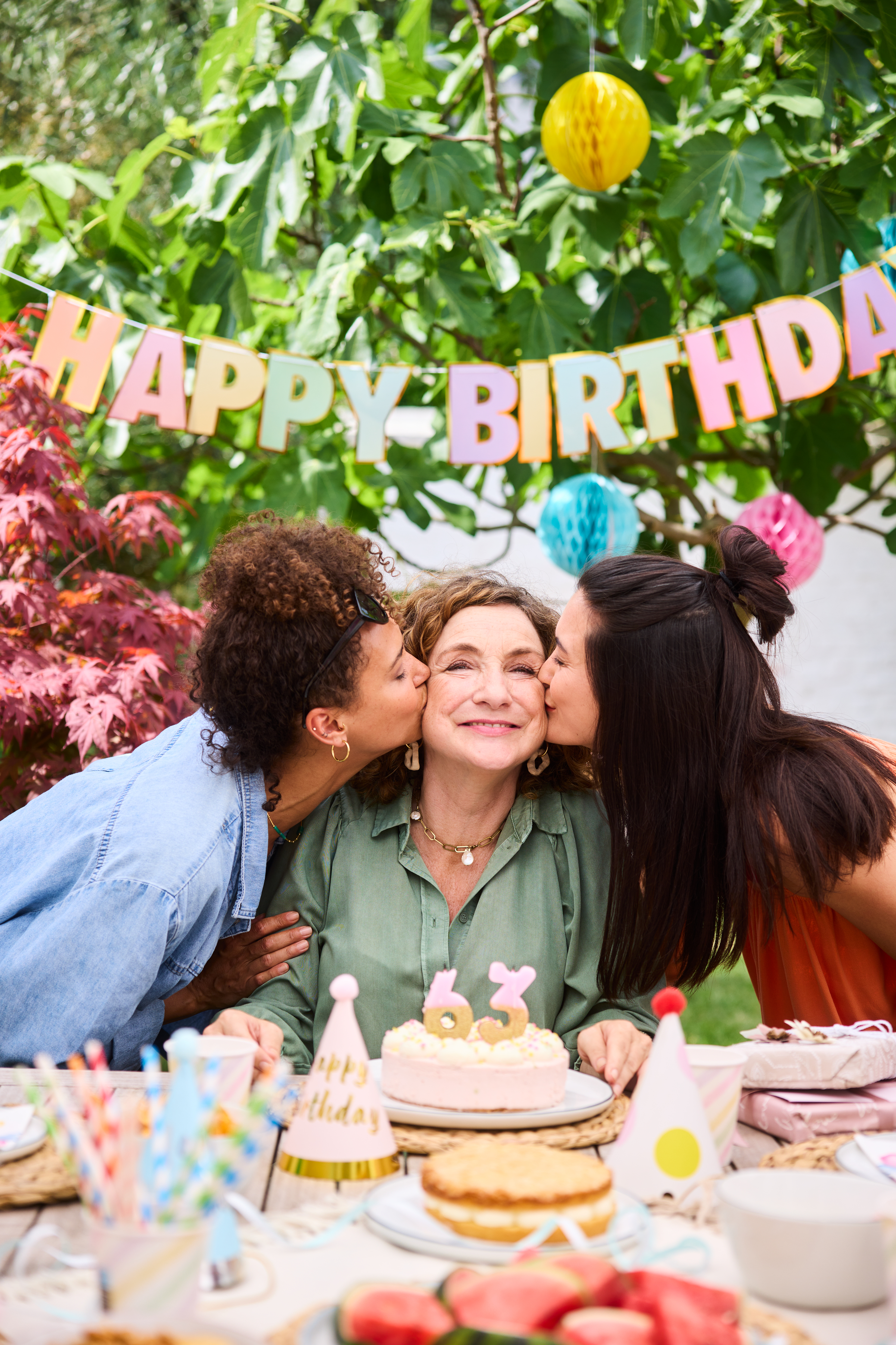 Mutter mit Töchtern im Garten zur Geburtstagsfeier