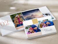 Giv en fotobog som årbog til jul To fotobøger ligger stablet oven på hinanden. De er fyldt med familiebilleder fra det forgangne år.