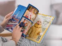 Pixum Fotoboek Een vrouw bladert door een Pixum Fotoboek met winterse familiefoto's