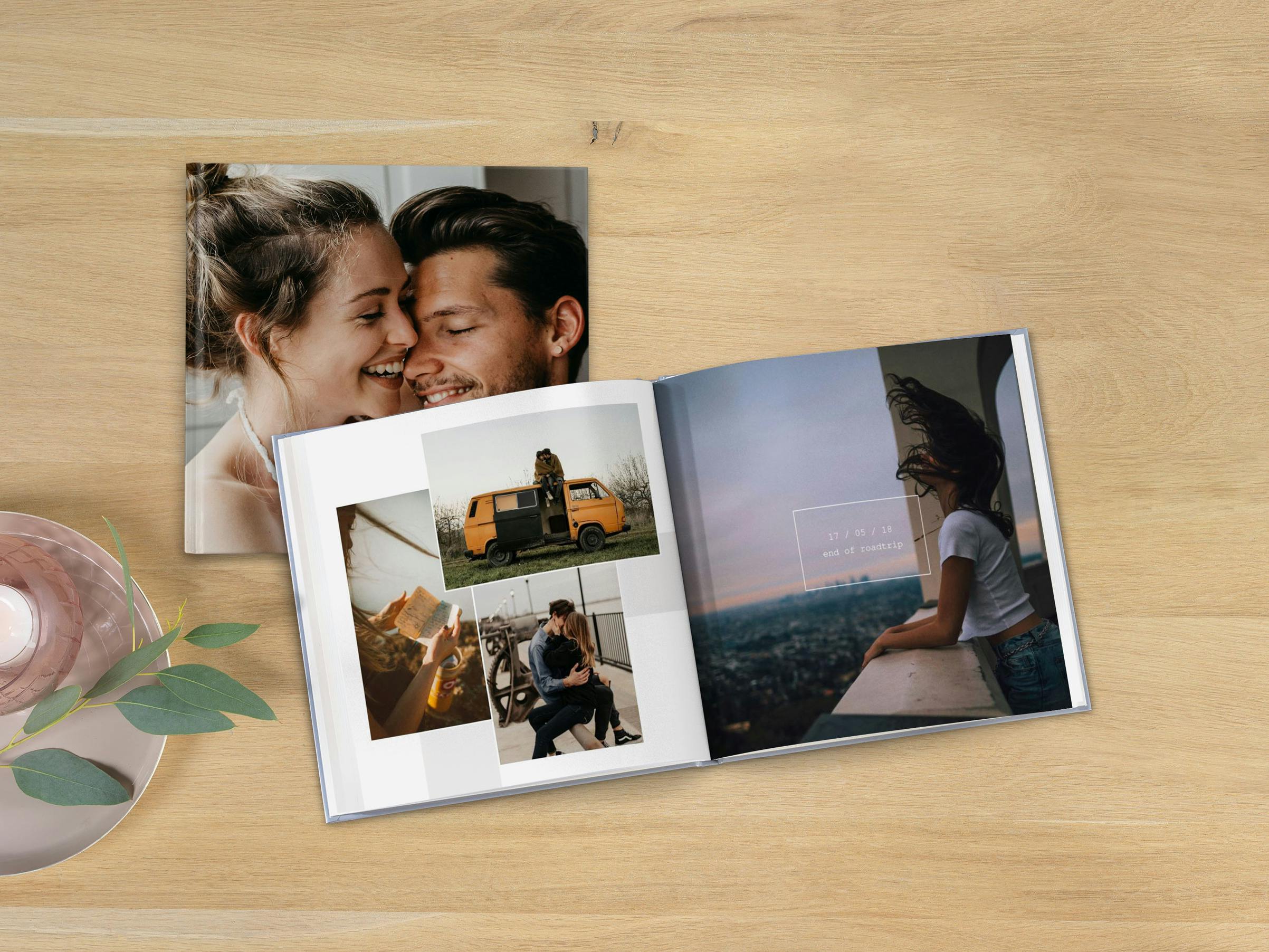 Álbum de fotos cuadrado con fotos de una pareja en diseños modernos sobre una mesa de madera
