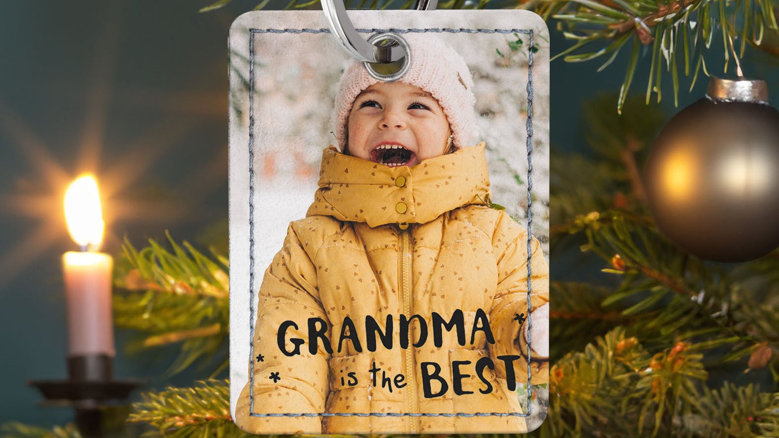 Schlüsselanhänger als Weihnachtsbaumschmuck Schlüsselanhänger mit einem kleinen Mädchen und der Aufschrift "Grandma is the Best" am Weihnachtsbaum