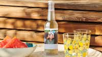 Limonadenflasche mit einem personalisierten Etikett Limonadenflasche mit einem personalisierten Etikett auf einem sommerlich gedecktem Tisch