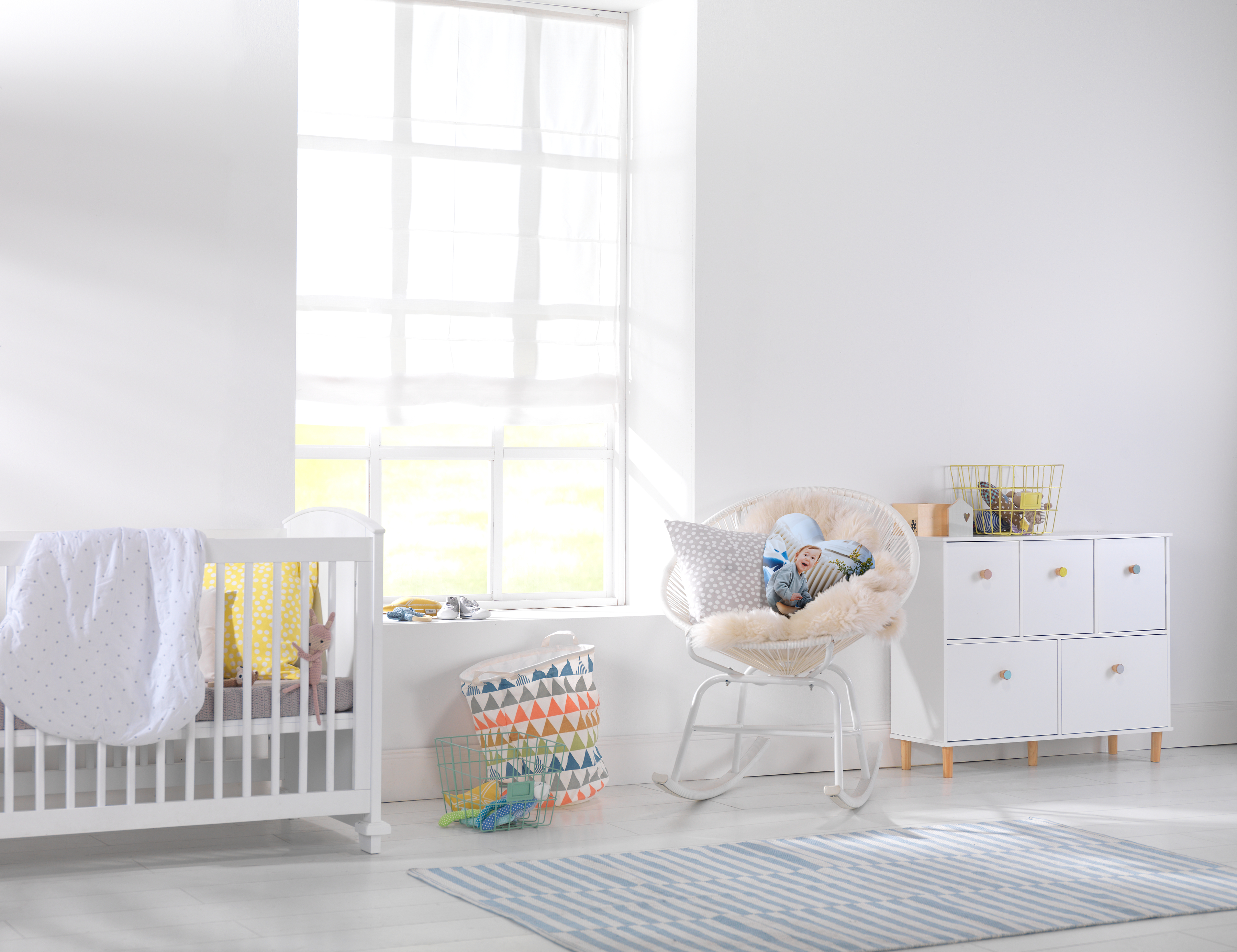 Herzkissen mit Foto von einem Baby liegt auf einem Sessel