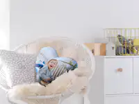 Herzkissen mit Foto gestalten Herzkissen mit Foto von einem Baby liegt auf einem Sessel