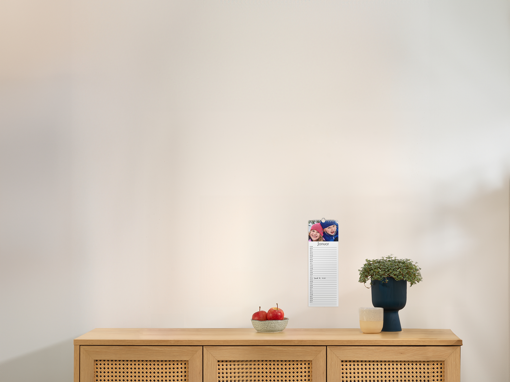 Keukenkalender groot aan een muur met een foto van kinderen