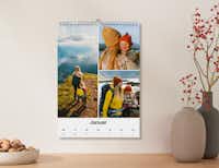 Wandkalender im A4 Format mit Spalten für jede Woche Kalender im A4 Format mit Bildern einer Familie und Spalten zum Eintragen von Terminen für jede Woche an einer Wand