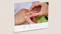 Portada de un álbum de fotos de boda En un álbum de fotos colocado en posición vertical se ve una foto de una boda. En la foto, los novios se están intercambiando los anillos. En la parte superior de la foto aparece el título «Just married». Debajo hay un segundo título: «Nuestra boda».
