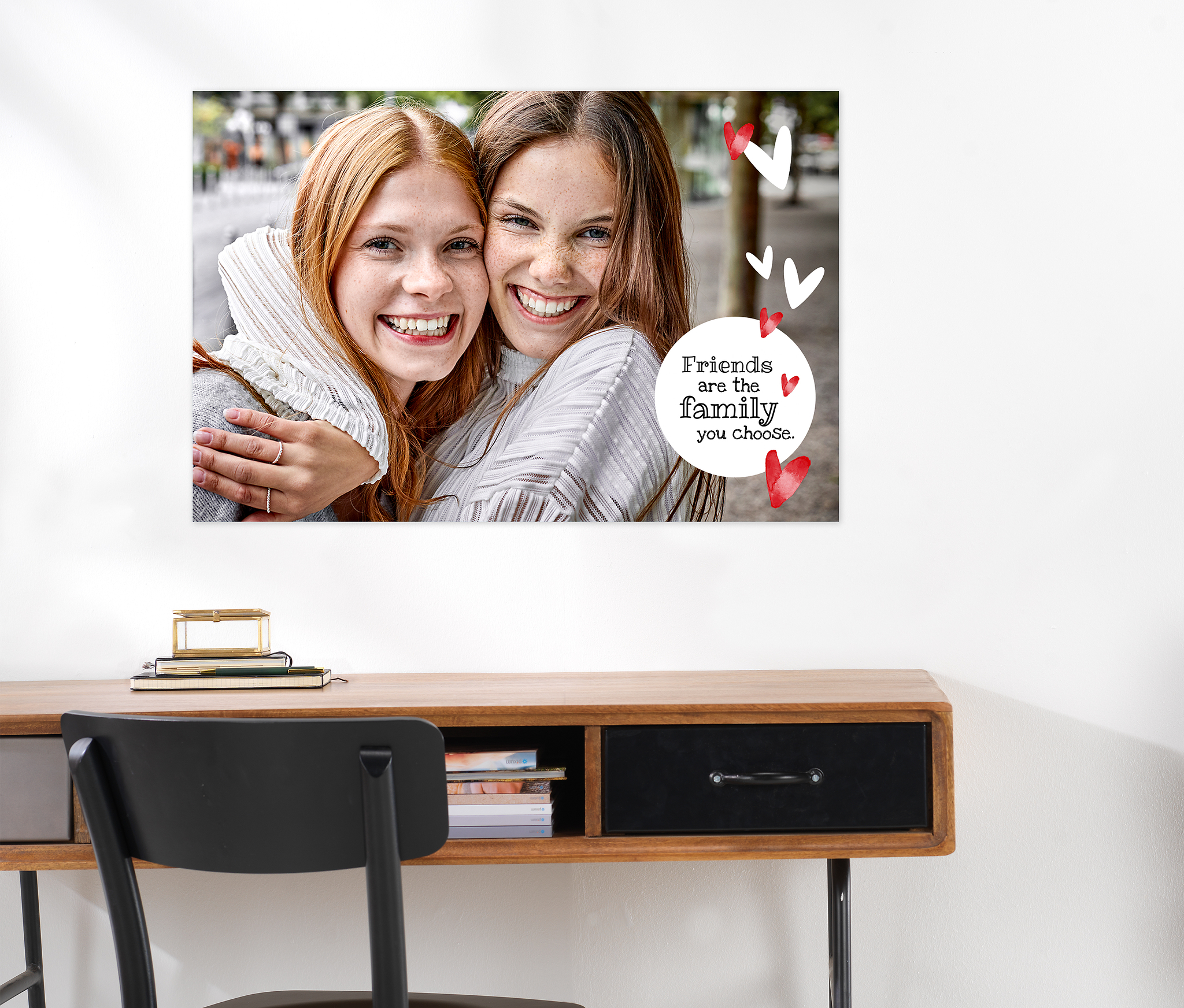 Póster personalizado con texto en formato 90 × 60 cm. En el póster aparece la foto de dos amigas y la frase «Friends are the family you choose». El póster está decorado con pequeños cliparts de corazones.