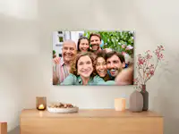 Lienzo fotográfico de Pixum con una foto familiar Un lienzo con un retrato familiar cuelga de la pared