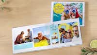 Pixum vakantie fotoboek Een fotoboek met vrolijke vakantiefoto's en een drankje met limoen en kruiden op een houten tafel.