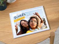 Fotobuch auf einem Tisch Ein Pixum Fotobuch im großen Hochformat, welches auf einem Tisch liegt. Auf dem Cover steht "Best Friends Forever".