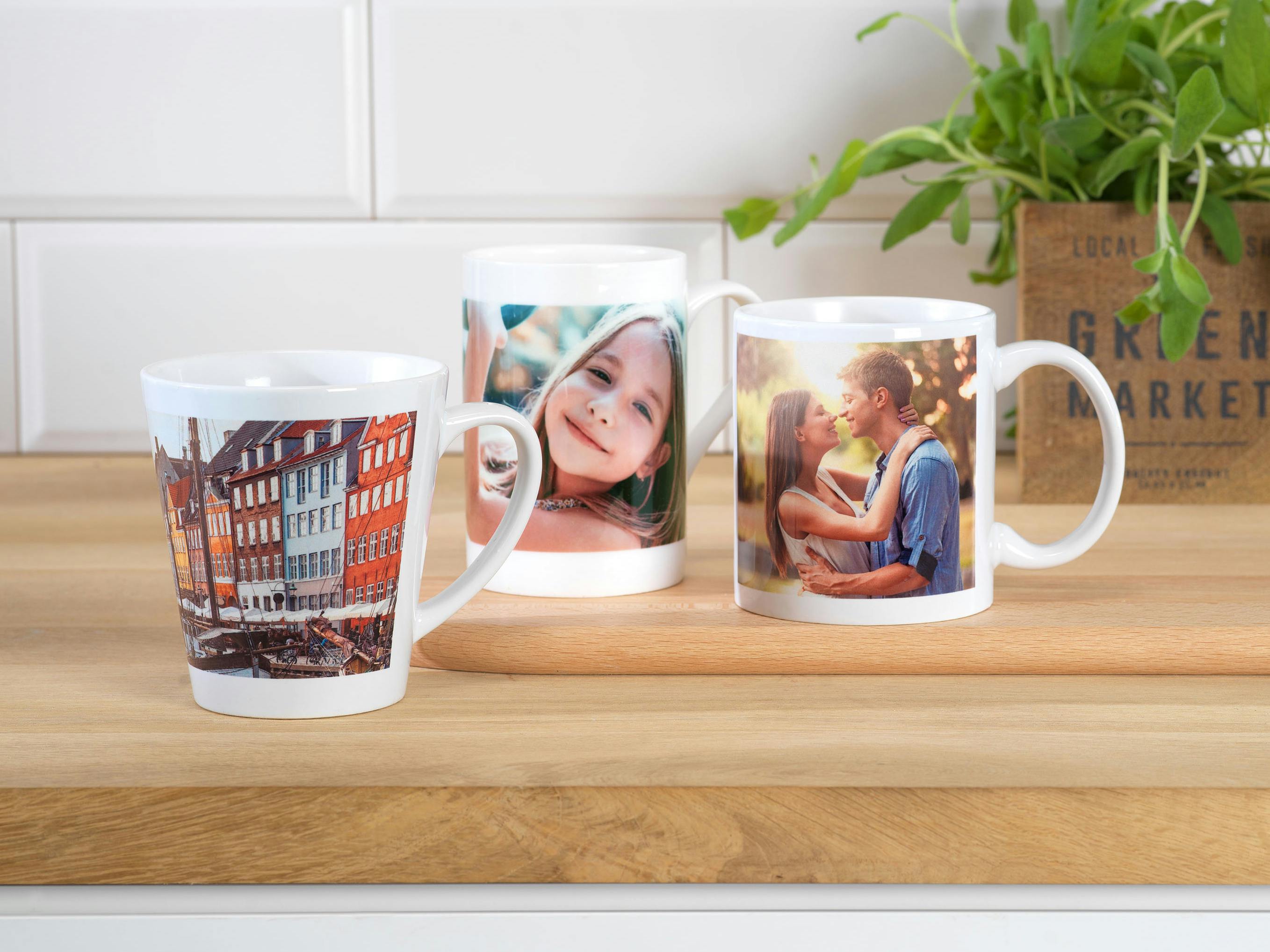 Trois tasses et mugs photo sur une table en bois avec photos de couple, d'une petite fille et de Copenhague.