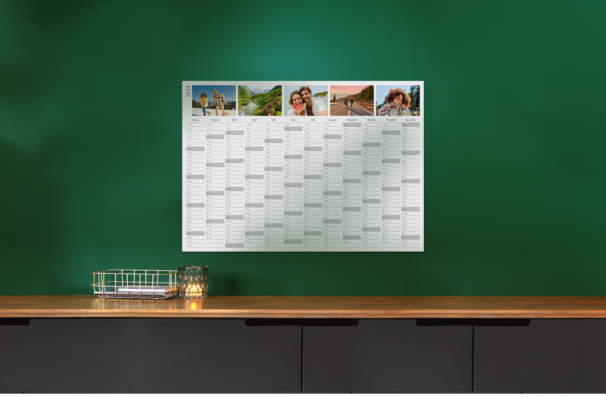 Ein Jahresplaner für das Jahr 2024 hängt an einer grünen Wand, geschmückt mit verschiedenen saisonalen Fotos über den Monatsnamen. 