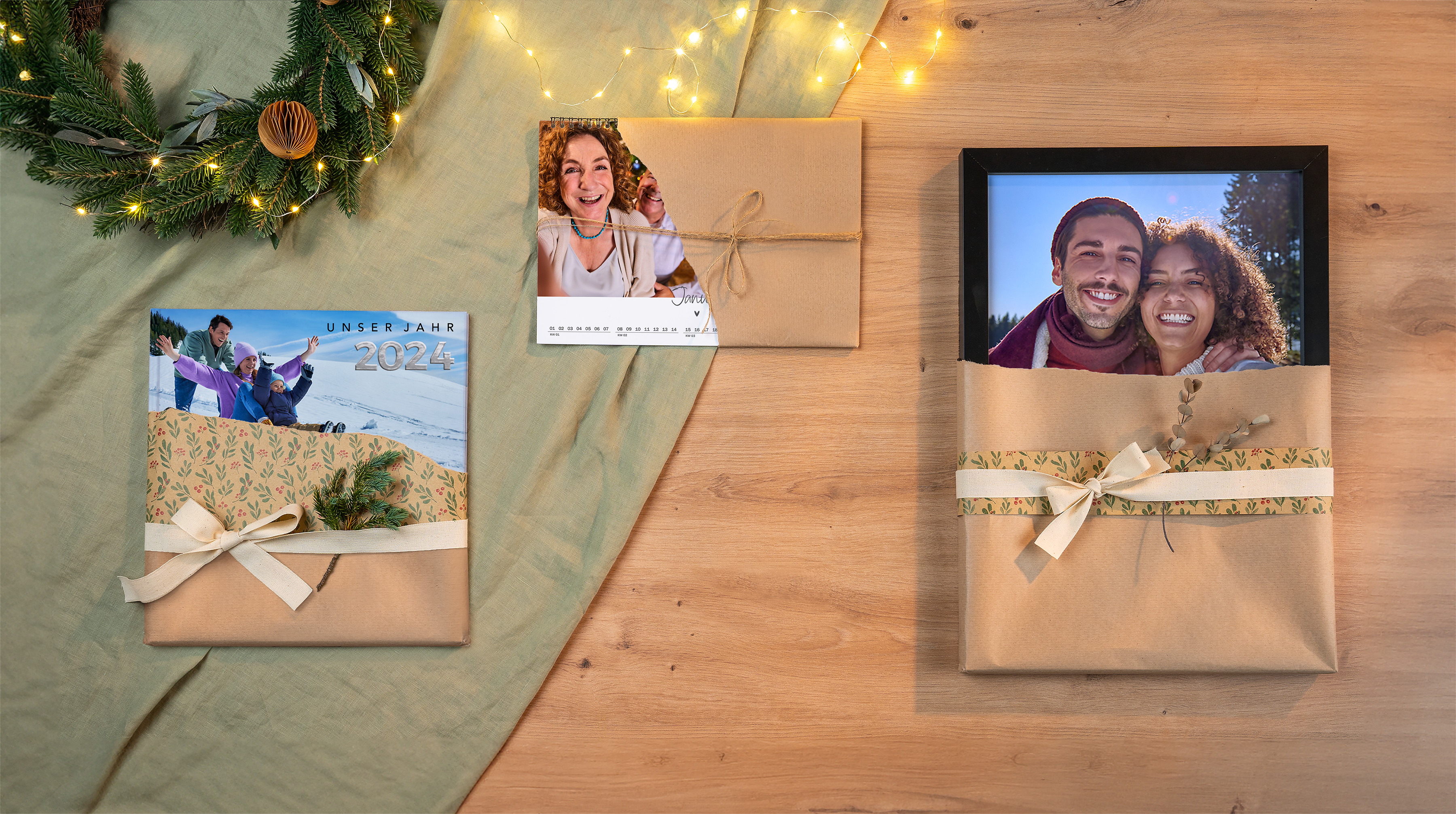 Ein Fotobuch, ein Wandbild und ein Kalender als Weihnachtsgeschenke verpackt