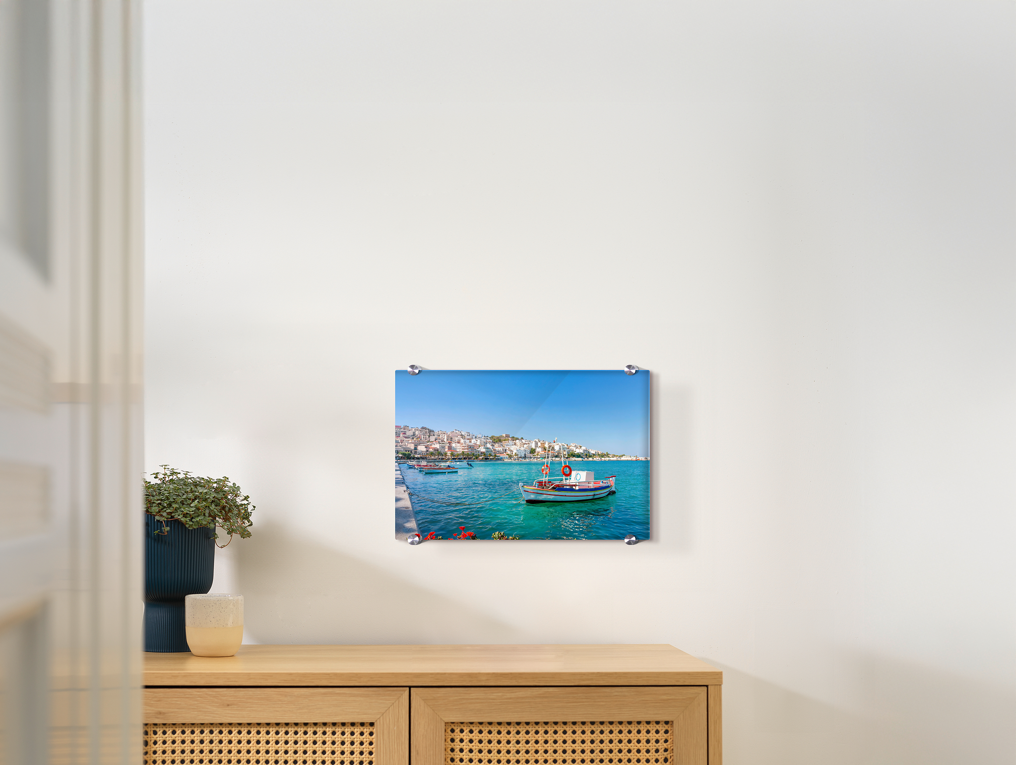 Een foto op plexiglas hangt aan een muur. Het gaat om een vakantiefoto.