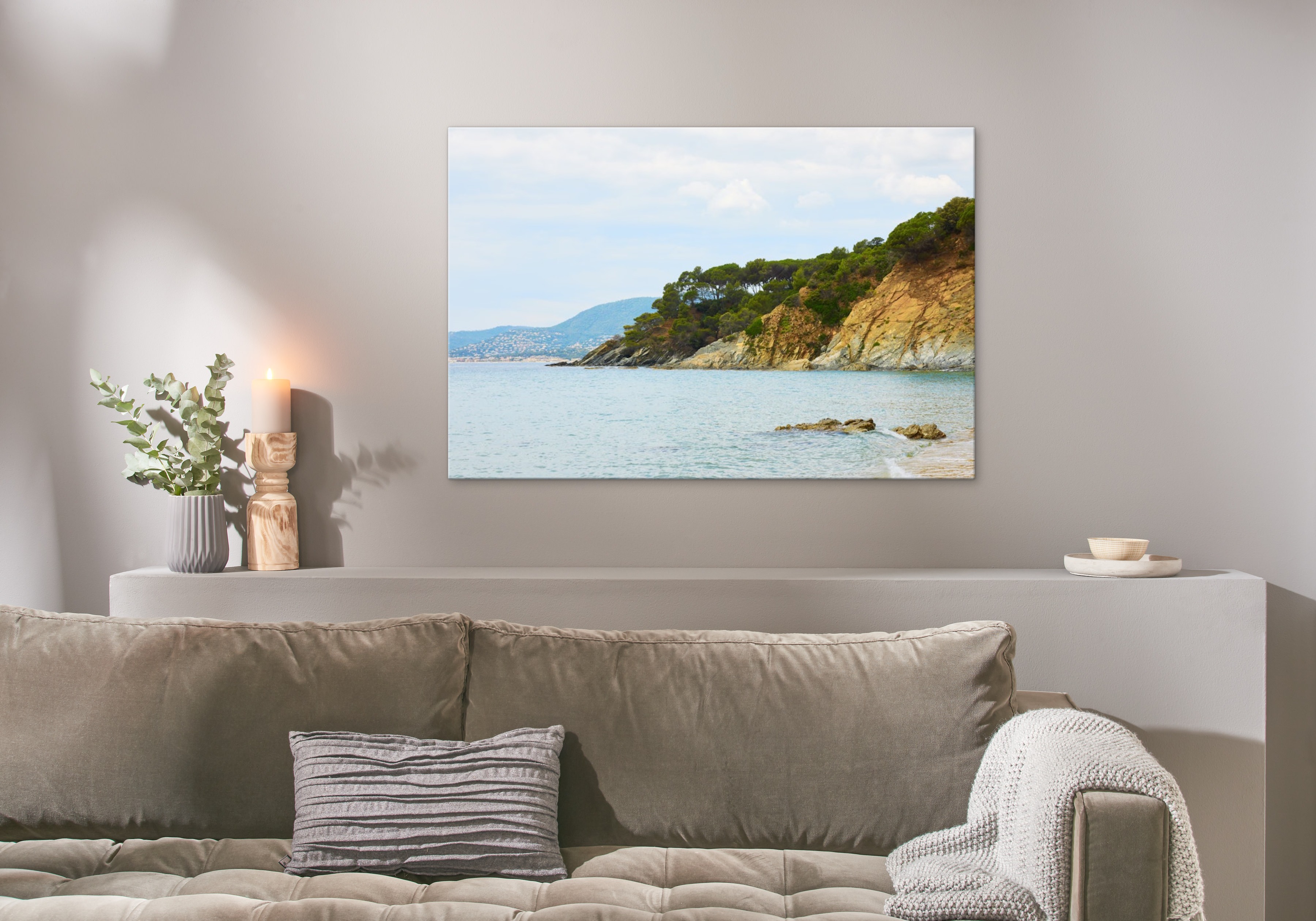 Photo sur toile au format 120x80 cm avec une photo de la mer accroché au dessu d'un canapé. 