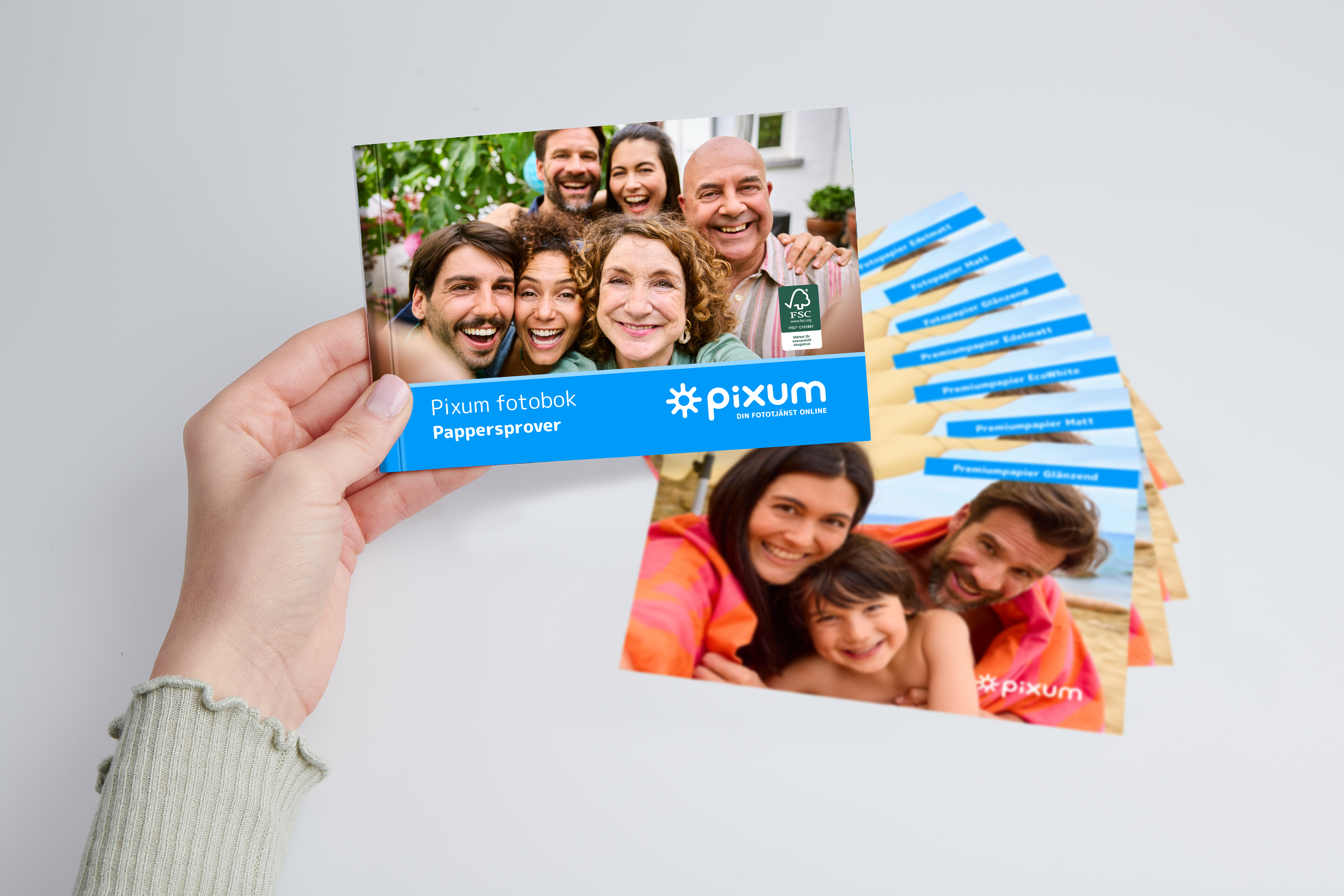 En person håller Pixum pappersprovsset i handen.