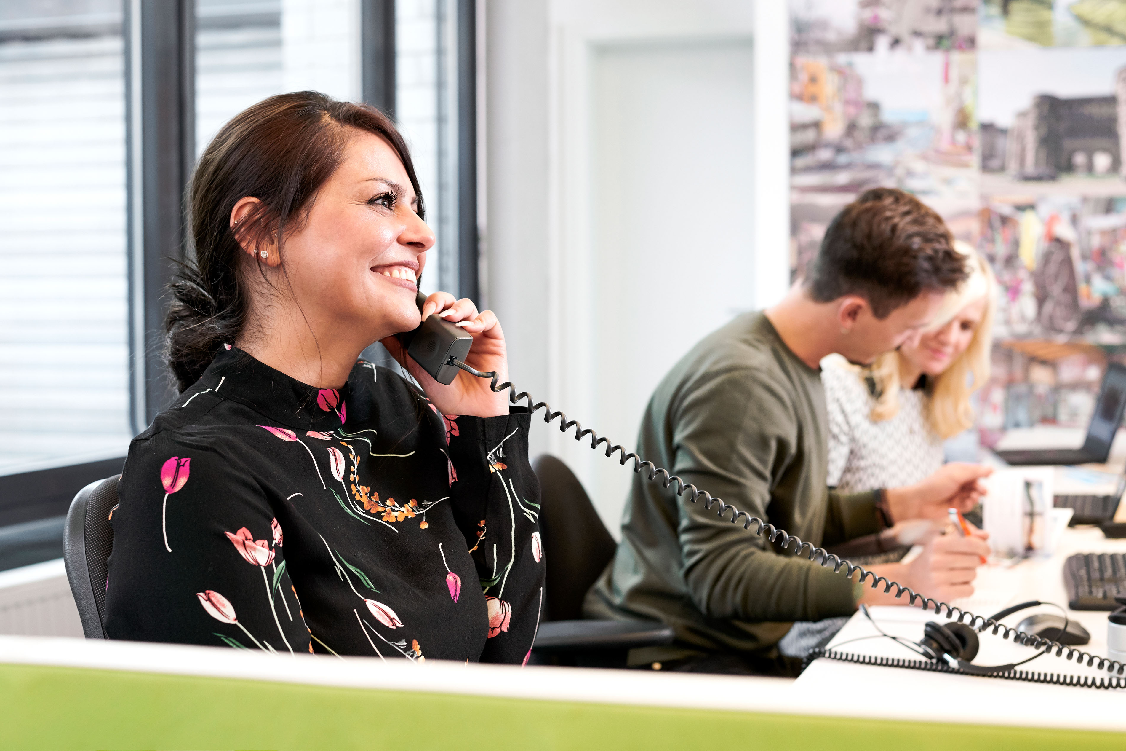 Een medewerker van de Pixum klantenservice telefoneert.