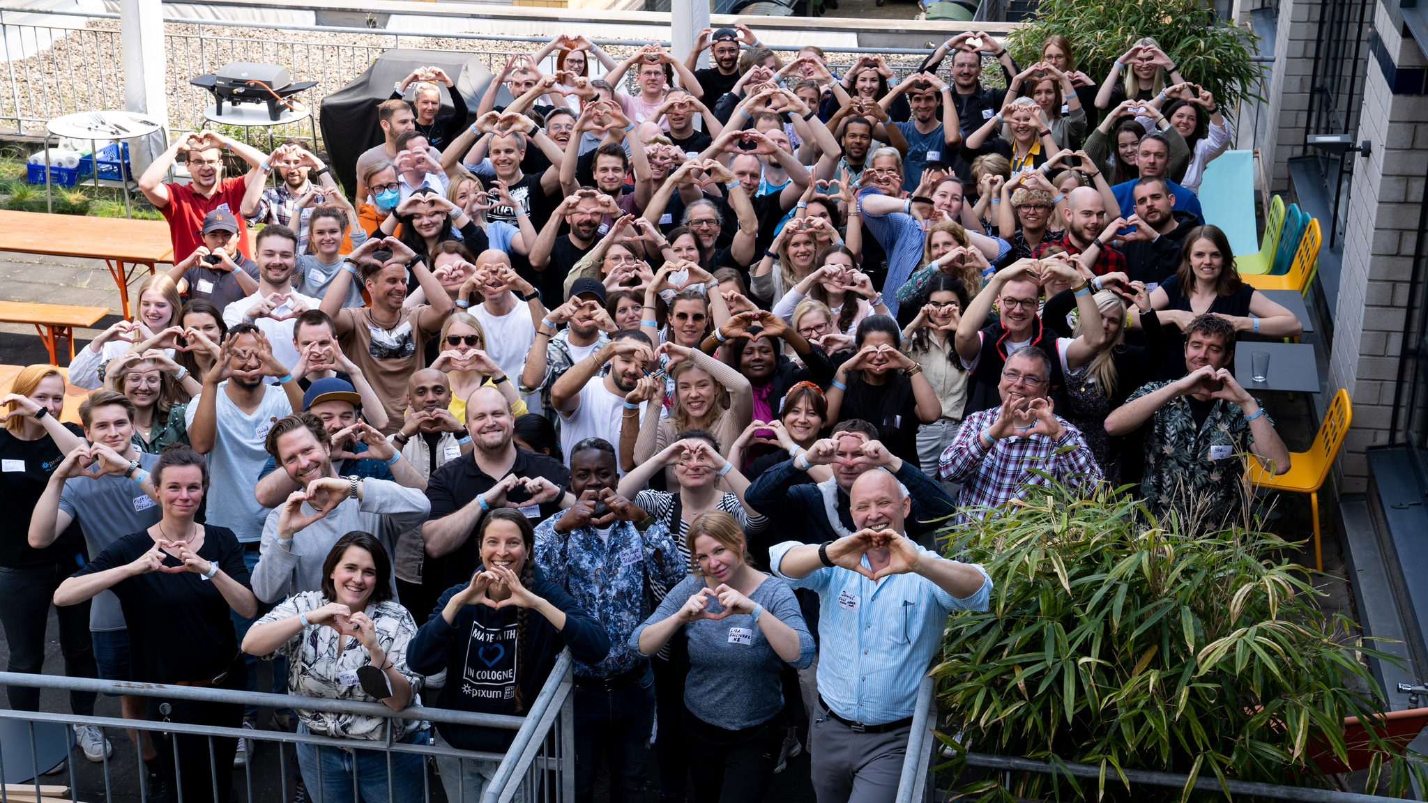 Pixum Mitarbeiter:innen, die jubelnd die Hände in die Höhe halten