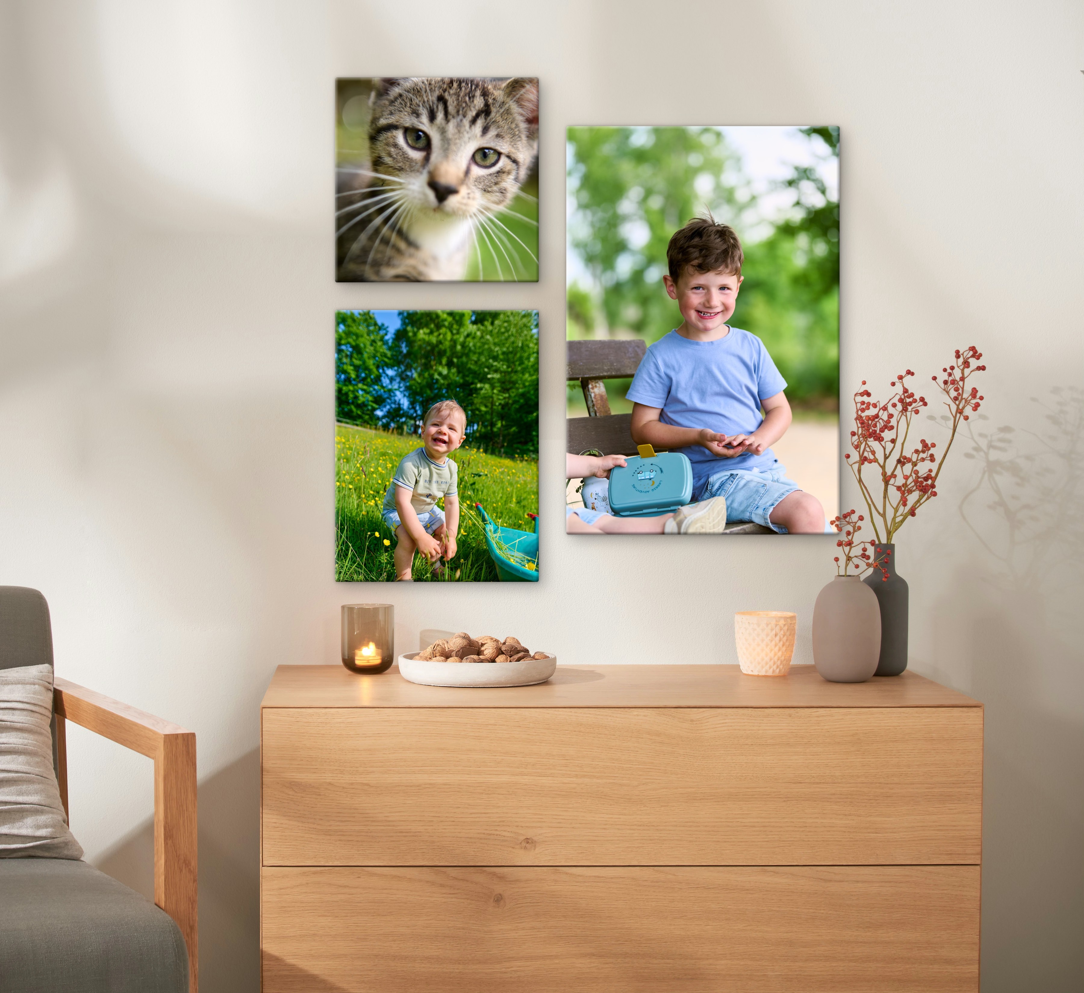 Mehrere Fotoleinwände mit Familienfotos hängen an einer Wand