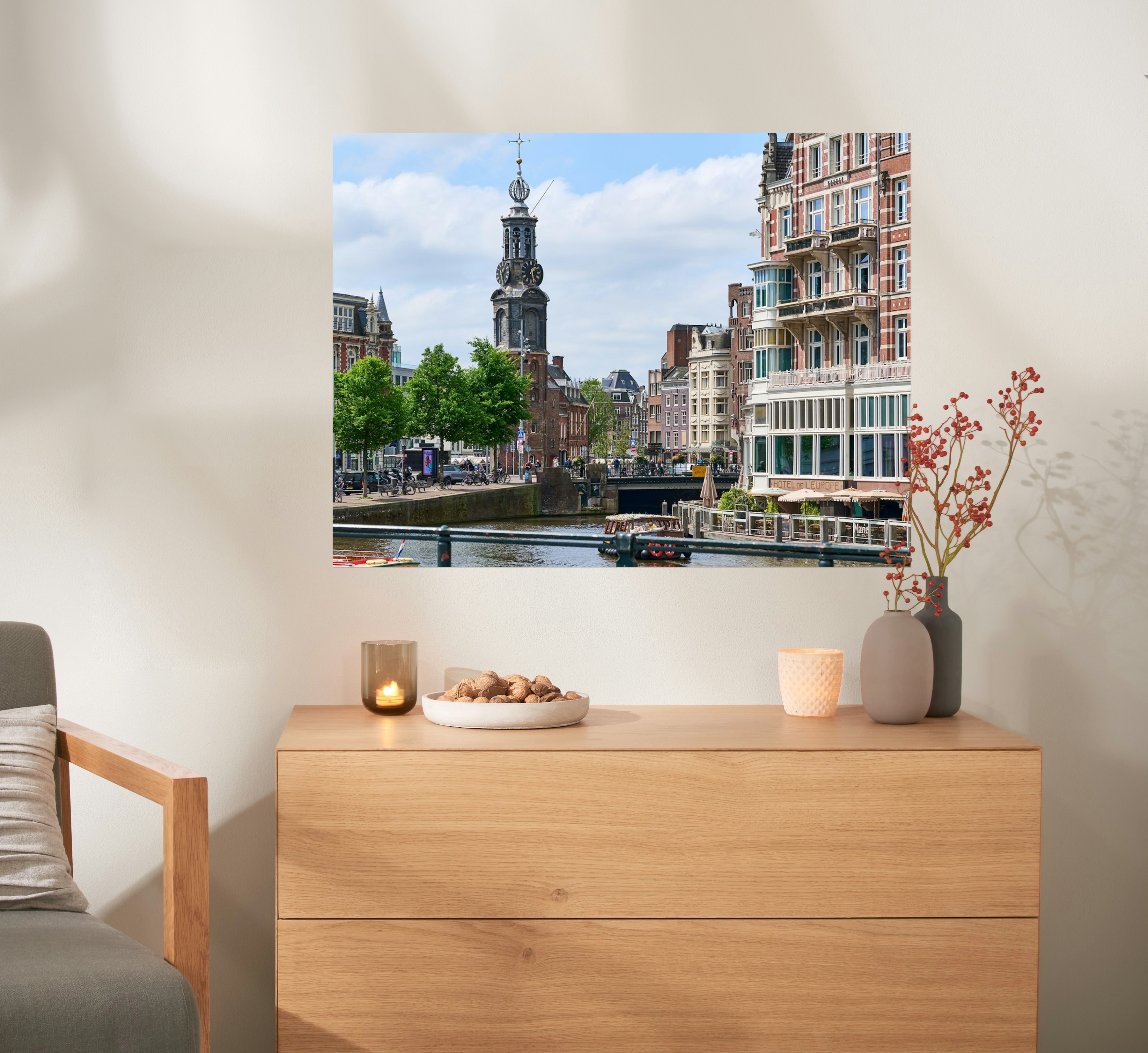 Een fotoposter in het formaat 80x60 met een foto van Amsterdam hangt boven een kast.