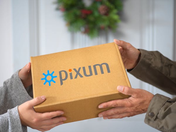 Een pakket van Pixum wordt overhandigd.