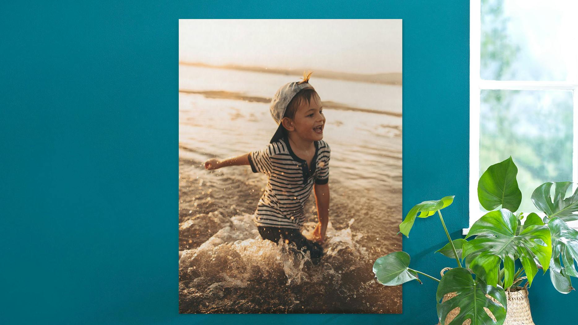 Gepersonaliseerde fotoposter met een klein jongetje op het strand aan een petrol muur