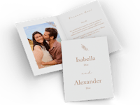 Trouwkaartjes ontwerpen met vouw Twee trouwkaartjes met vouw en een foto van een koppel liggen naast elkaar.