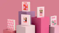 Fotobuch zum Muttertag gestalten Mehrere Fotobücher mit kreativen Muttertagsgestaltungen stehen in einem Setting verschiedener Säulen