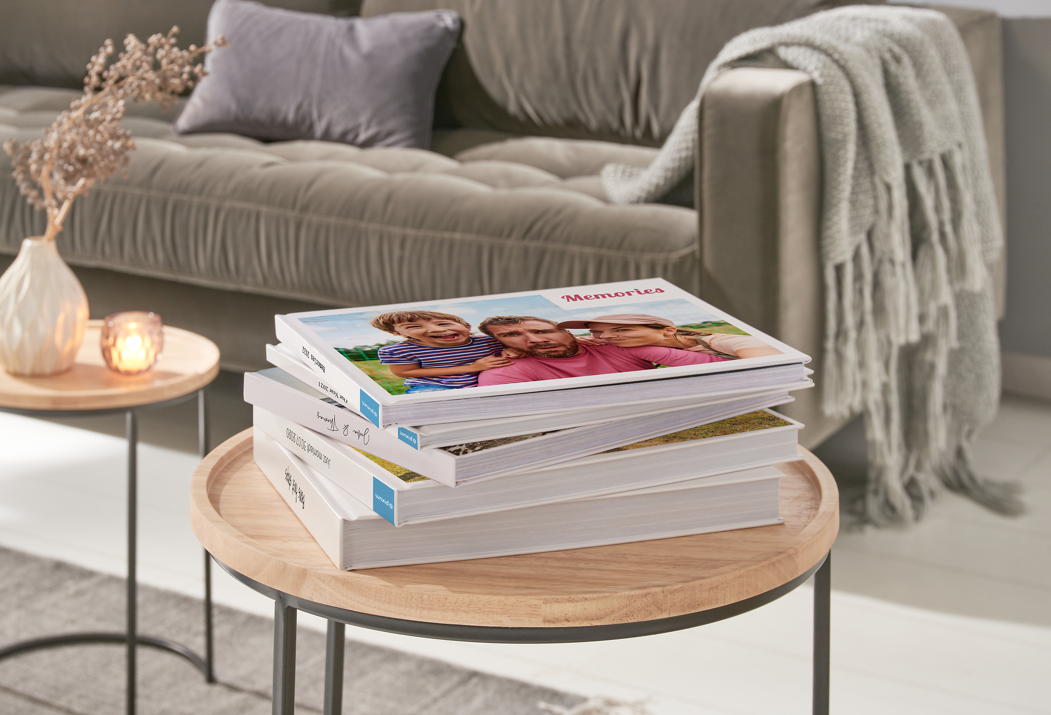 Ein Stapel Fotobücher mit einem Familienfoto auf dem Cover auf einem Couchtisch