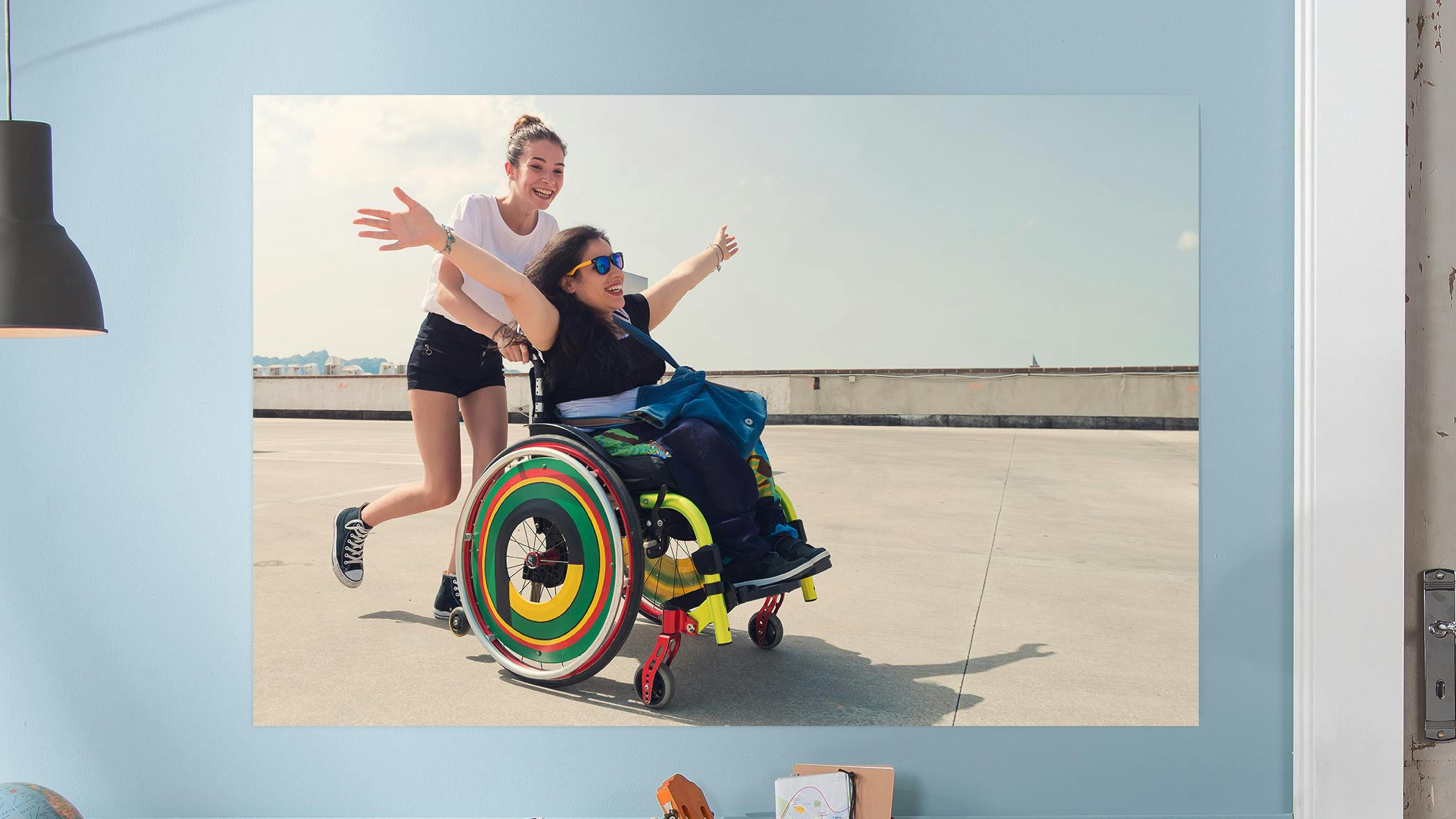 Gepersonaliseerde fotoposter met een foto van twee lachende vriendinnen, een zit in een rolstoel en de andere duwt de rolstoel
