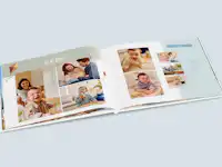 Babyalbum mit süßem Design Aufgeklapptes Babyfotobuch mit süßem Design. Die Seiten sind mit verschiedenen Fotos sowie kleinen Cliparts wie zum Beispiel einem Teddy Bären gestaltet.