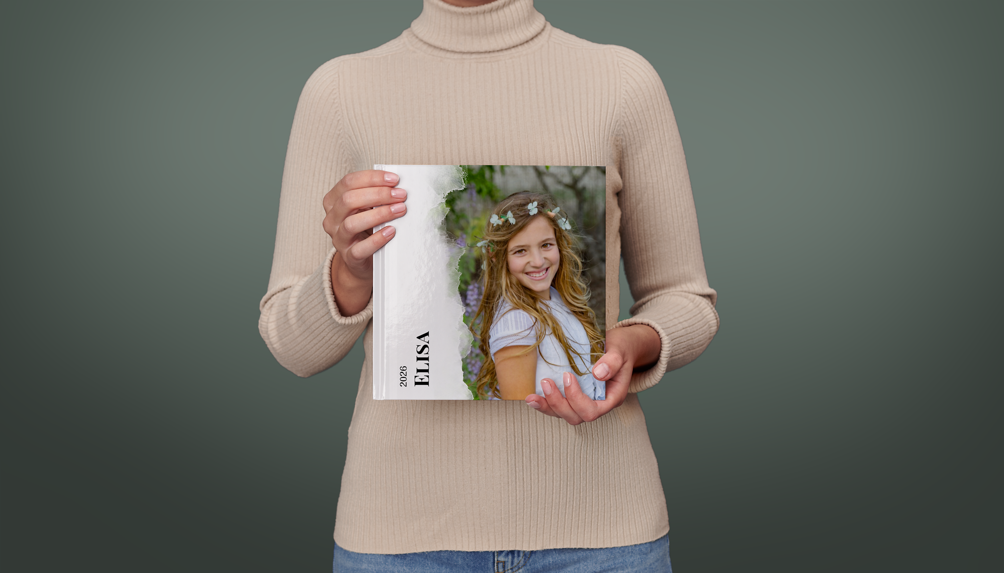 Una persona sostiene un álbum de fotos de comunión grande cuadrado con la foto de una niña y el nombre "Emma" en la portada