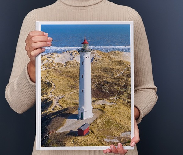 Una donna regge un Fotolibro Pixum XXL verticale