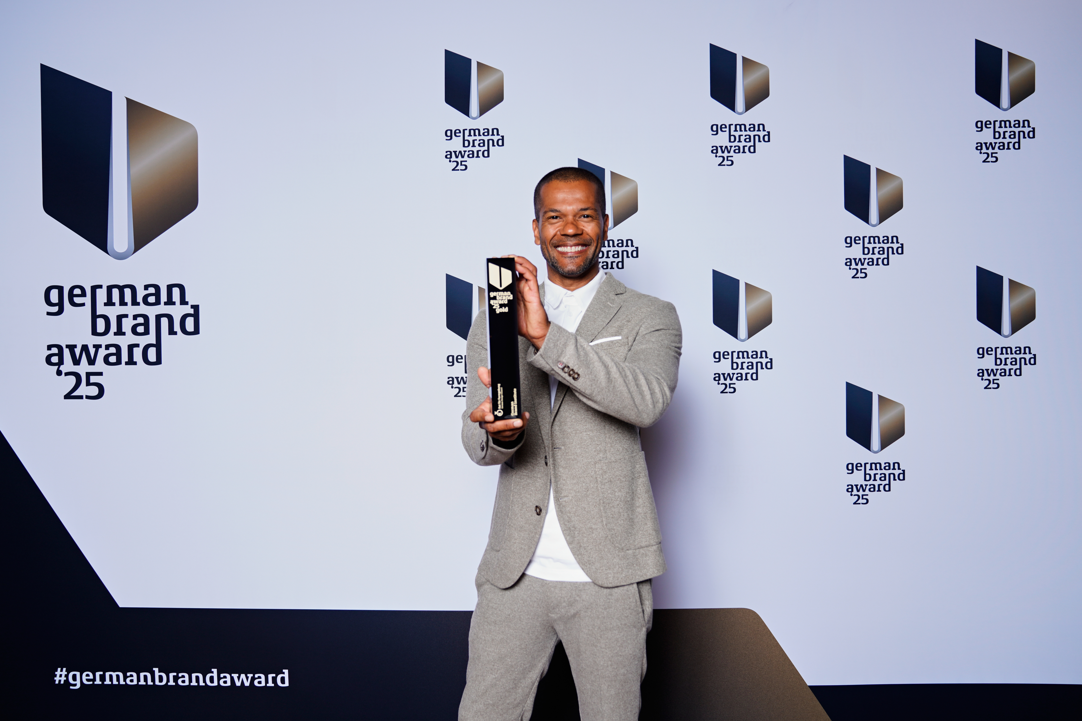 Ingo Kreutz van het PR-team van Pixum houdt de German Brand Award vast, die Pixum in het jaar 2025 kreeg.