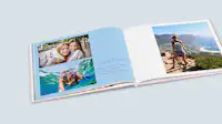 Freundschaftsfotobuch mit Urlaubsbildern Aufgeschlagenes Fotobuch mit Fotos von zwei Freundinnen. Die Linke Seite hat einen blauen Hintergrund und einen persönlichen Text.