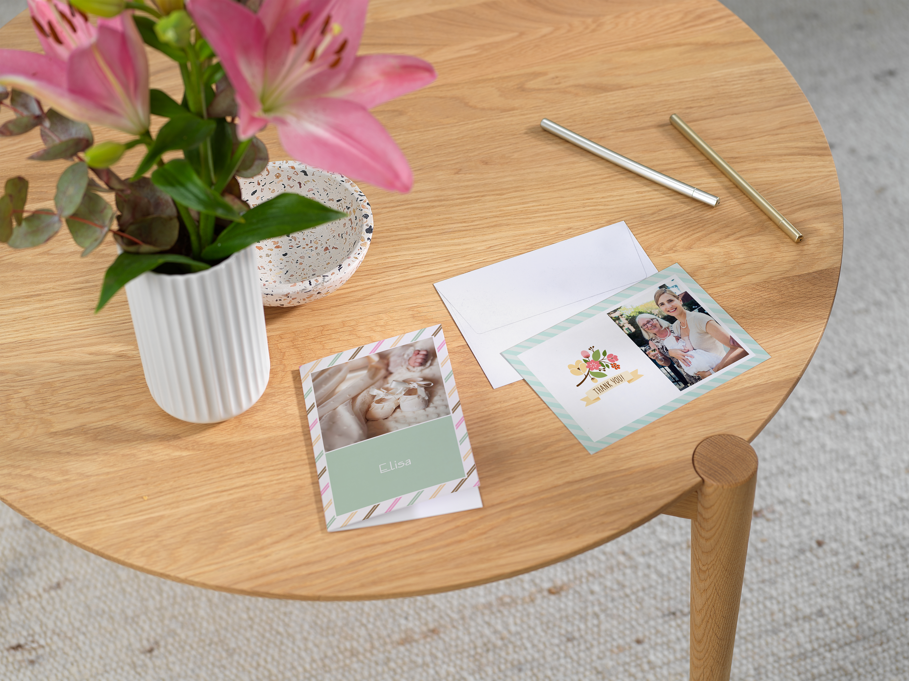 Tarejtas de bautizo personalizadas con fotos y texto apoyadas sobre una mesa