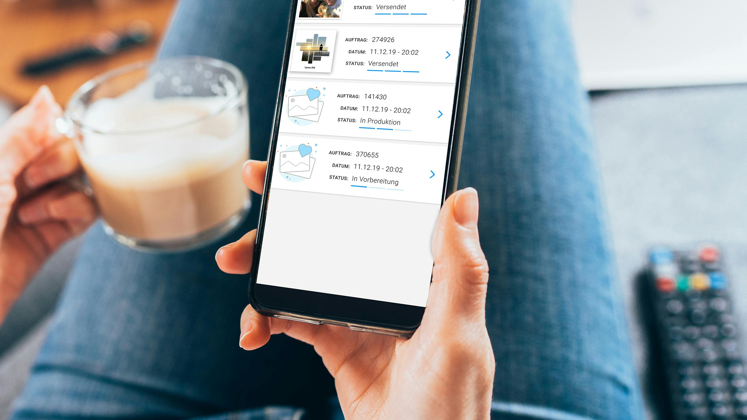 En hand med en mobil och på screenshot på Pixum appen med en beställningsöversikt. 