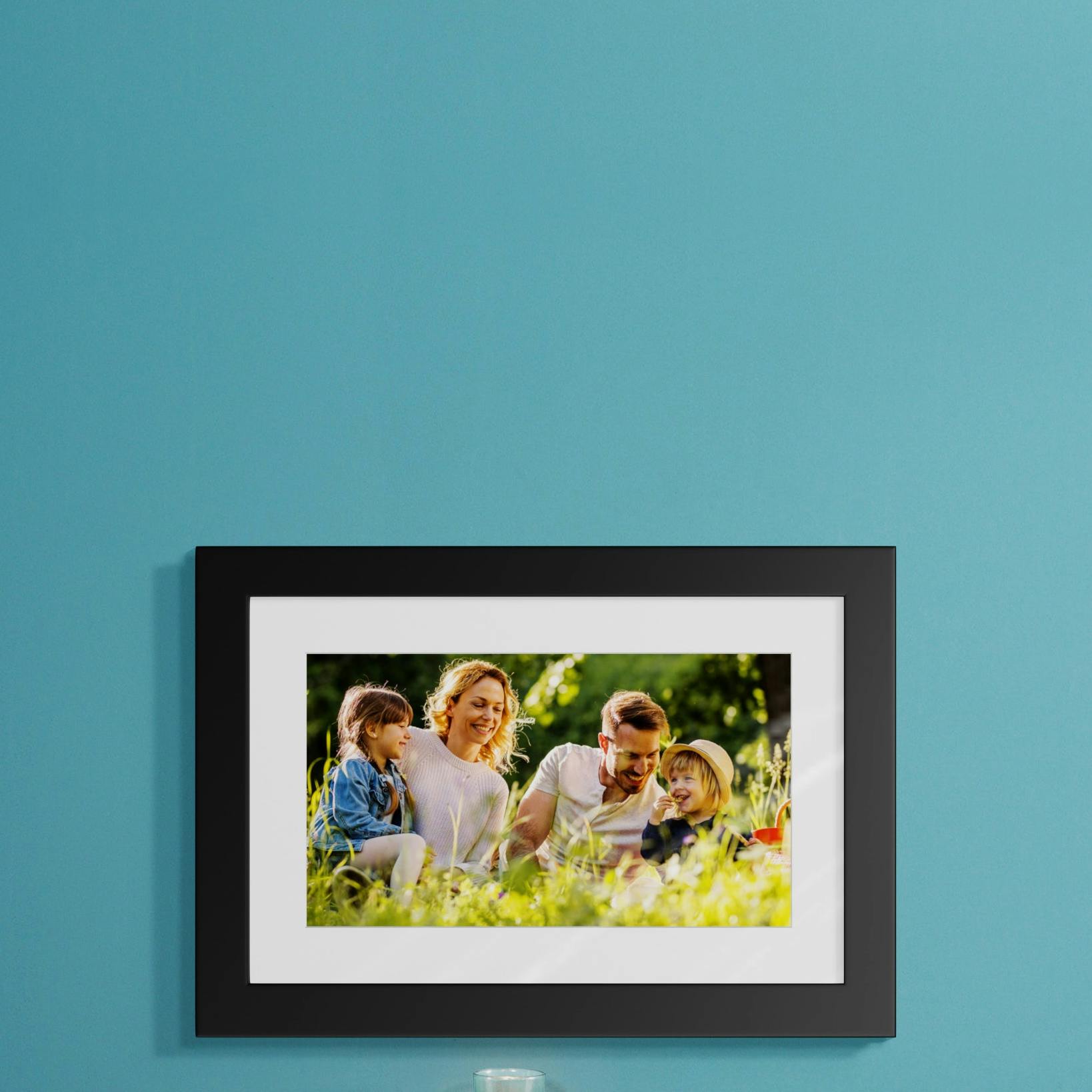 Foto en marco negro que refleja a una familia en un ambiente primaveral. 