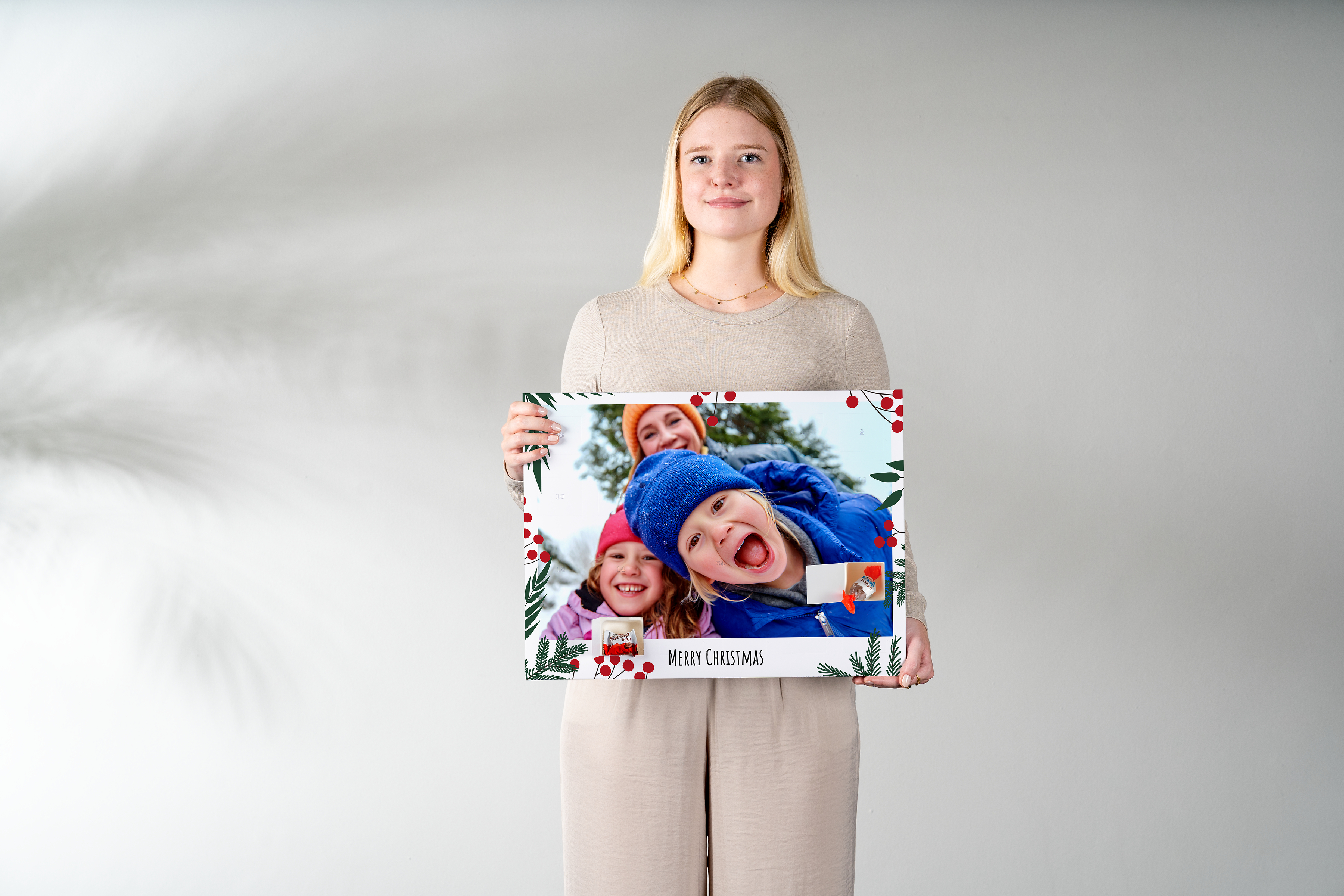 A woman holding a photo advent calendar with chocolate in her hands