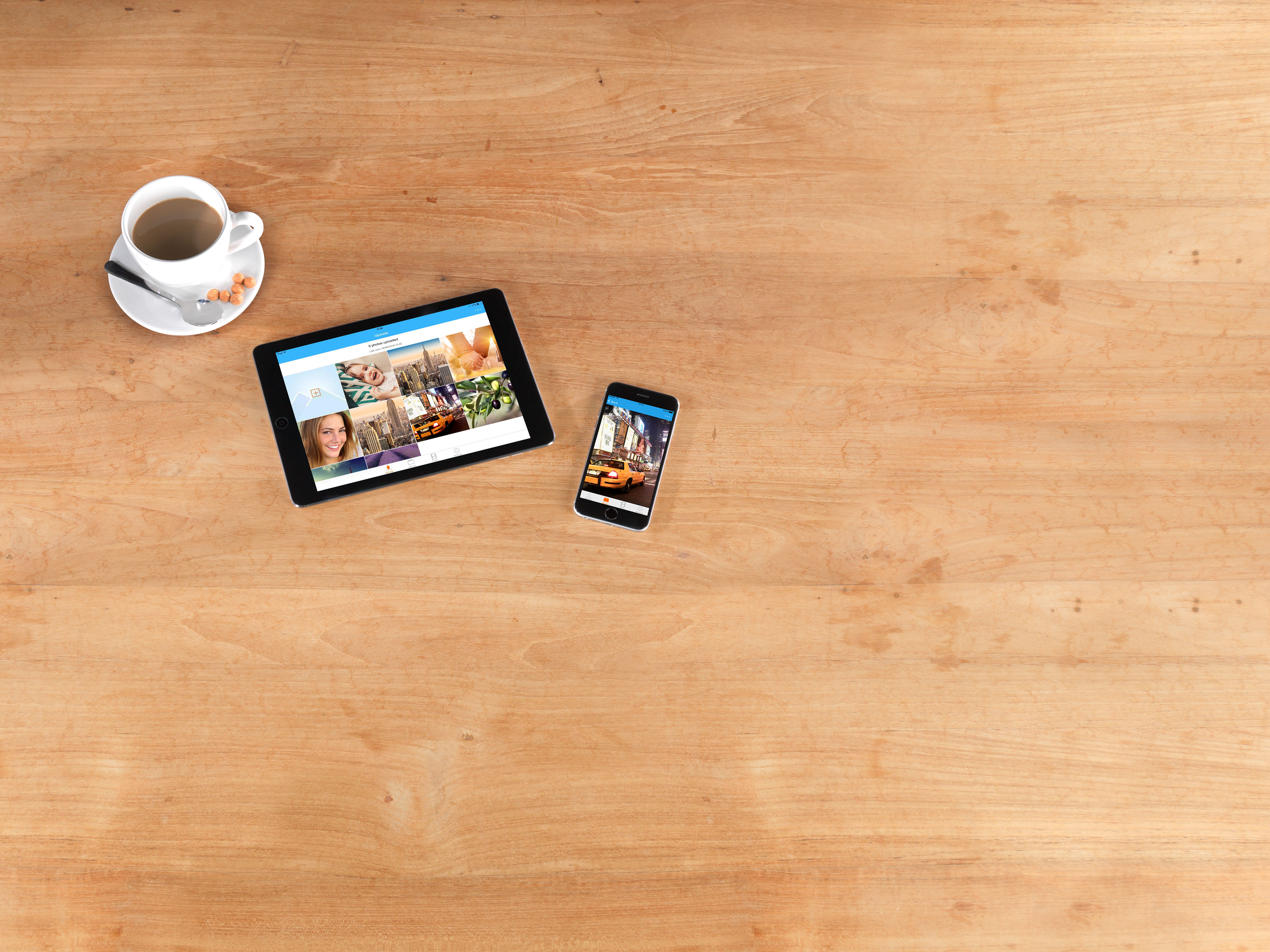Ein Tablet und ein Smartphone liegen auf einem Tisch, es ist eine Oberfläche zur Speicherung von Bildern geöffnet.