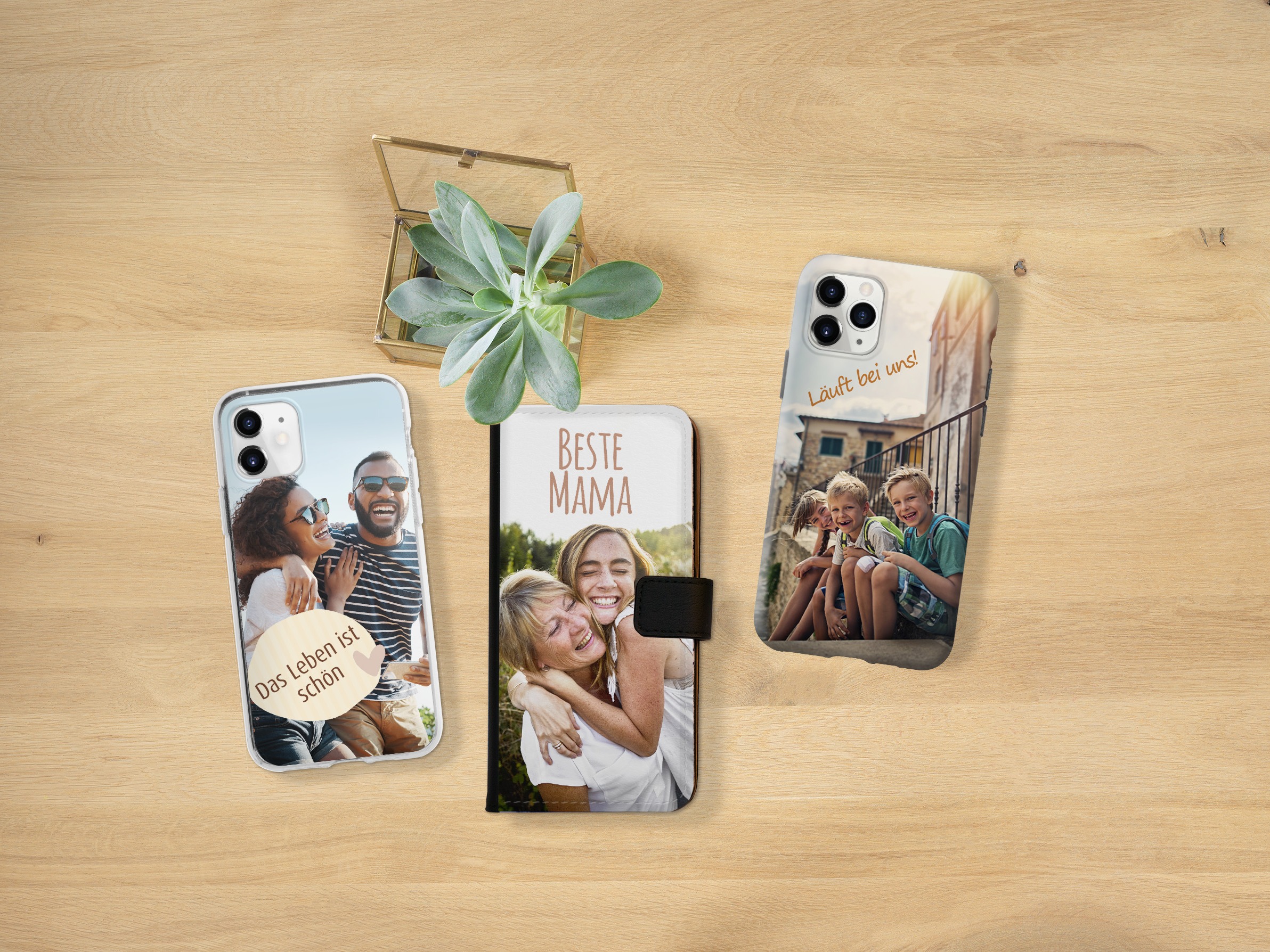 Drie gsm-hoesjes met familiefoto's liggen naast elkaar.