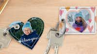 Sleutelhangers met foto's van kinderen Twee sleutelhangers met foto's van kinderen liggen op een tafel.