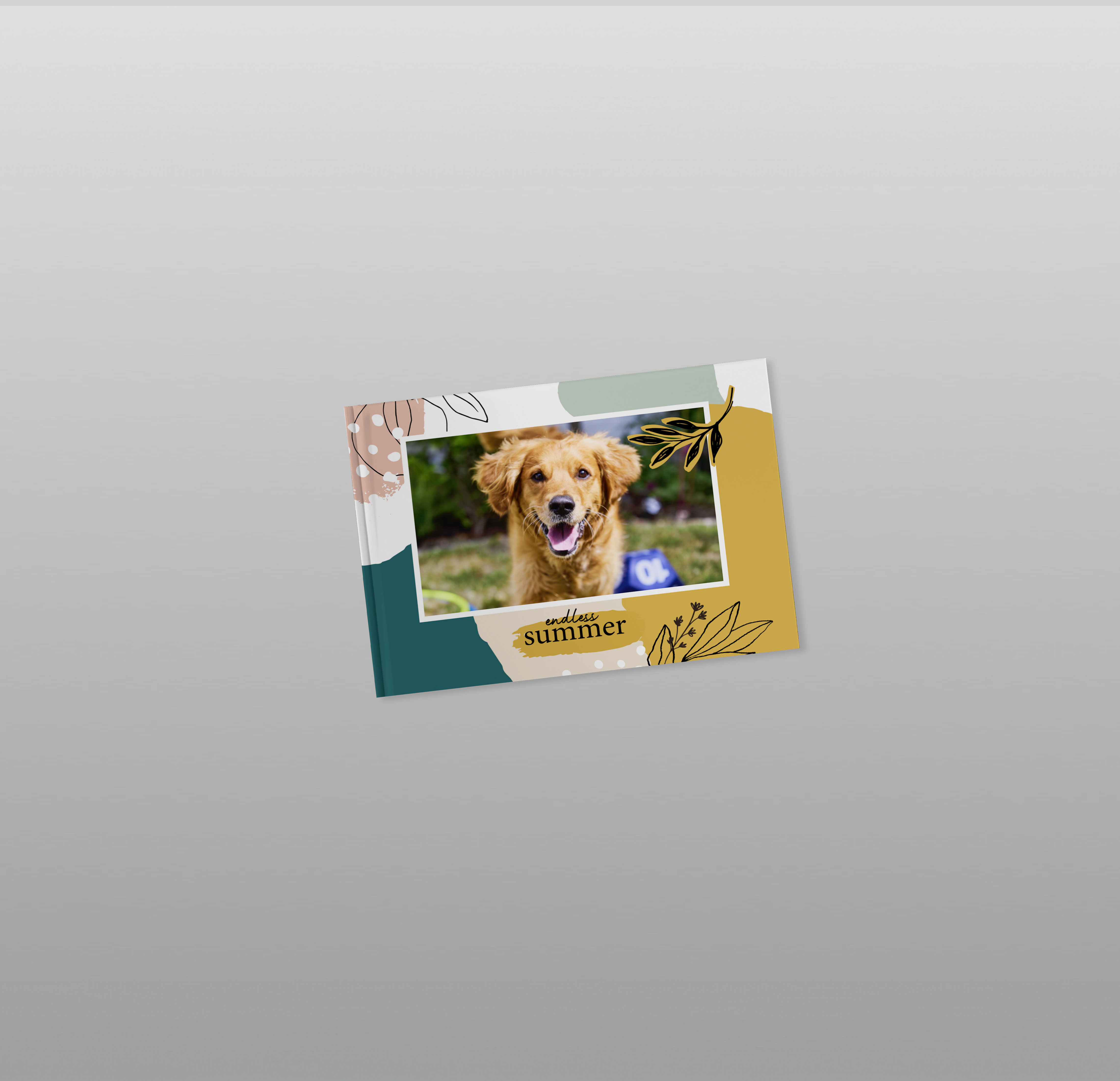 Auf einem grauen Hintergrund sieht man ein zugeklapptes Fotobuch mit buntem Cover und einem Hundebild. Der Titel des Fotobuchs lautet "Endless Summer".