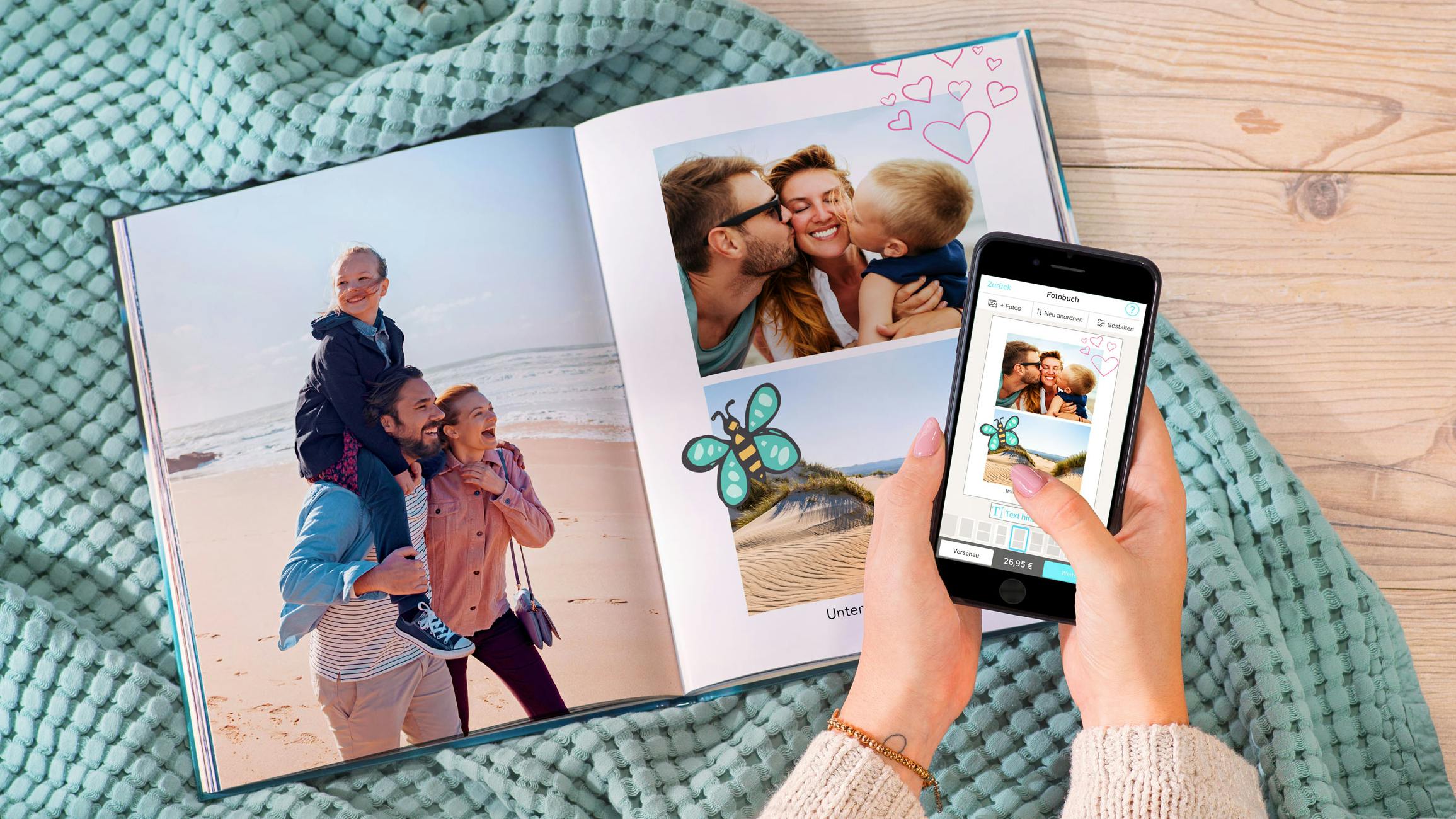 Opengeslagen fotoboek in staand formaat met zomerse foto's en cliparts en twee handen die een smartphone vasthouden