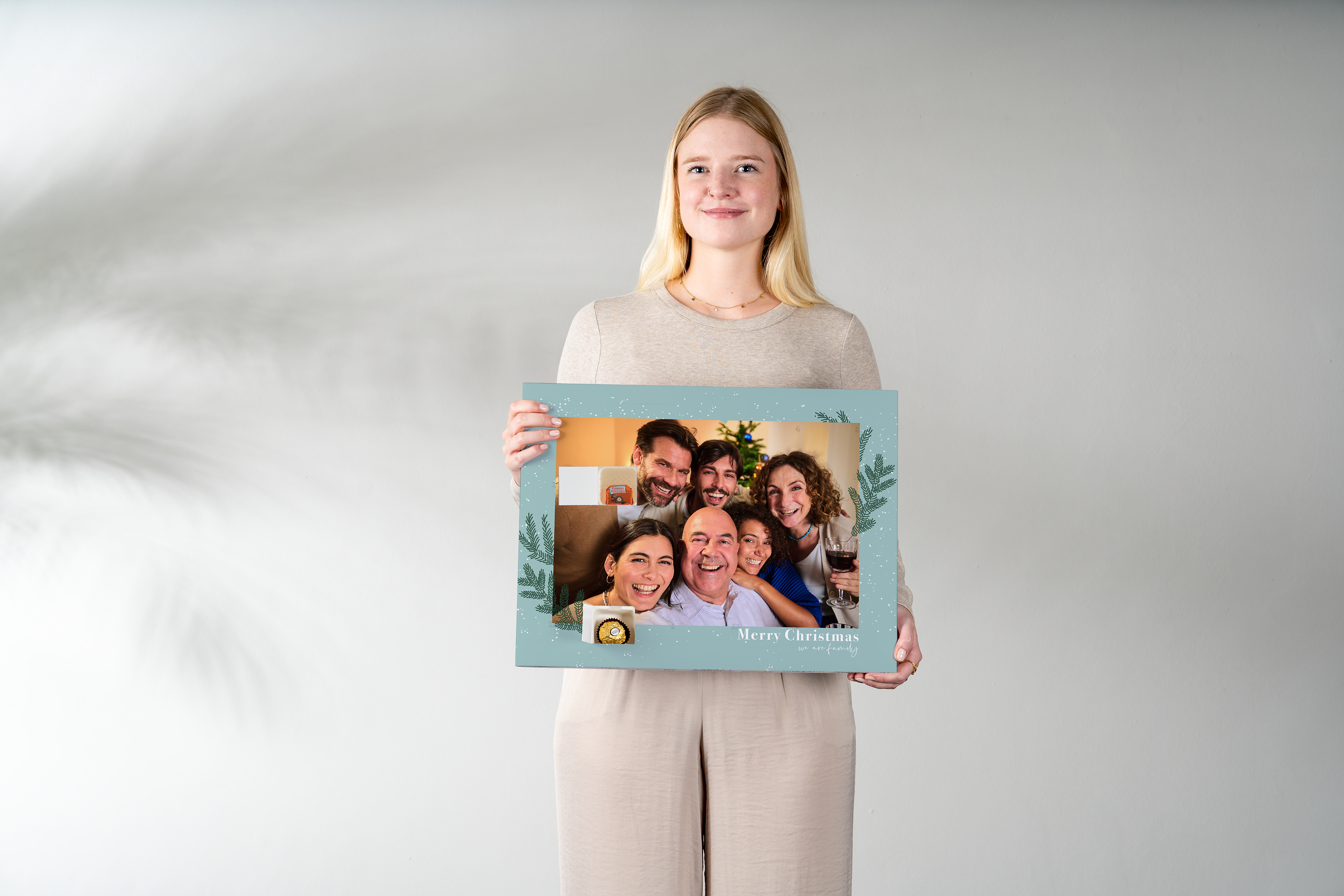 A woman holding a photo advent calendar with chocolate in her hands