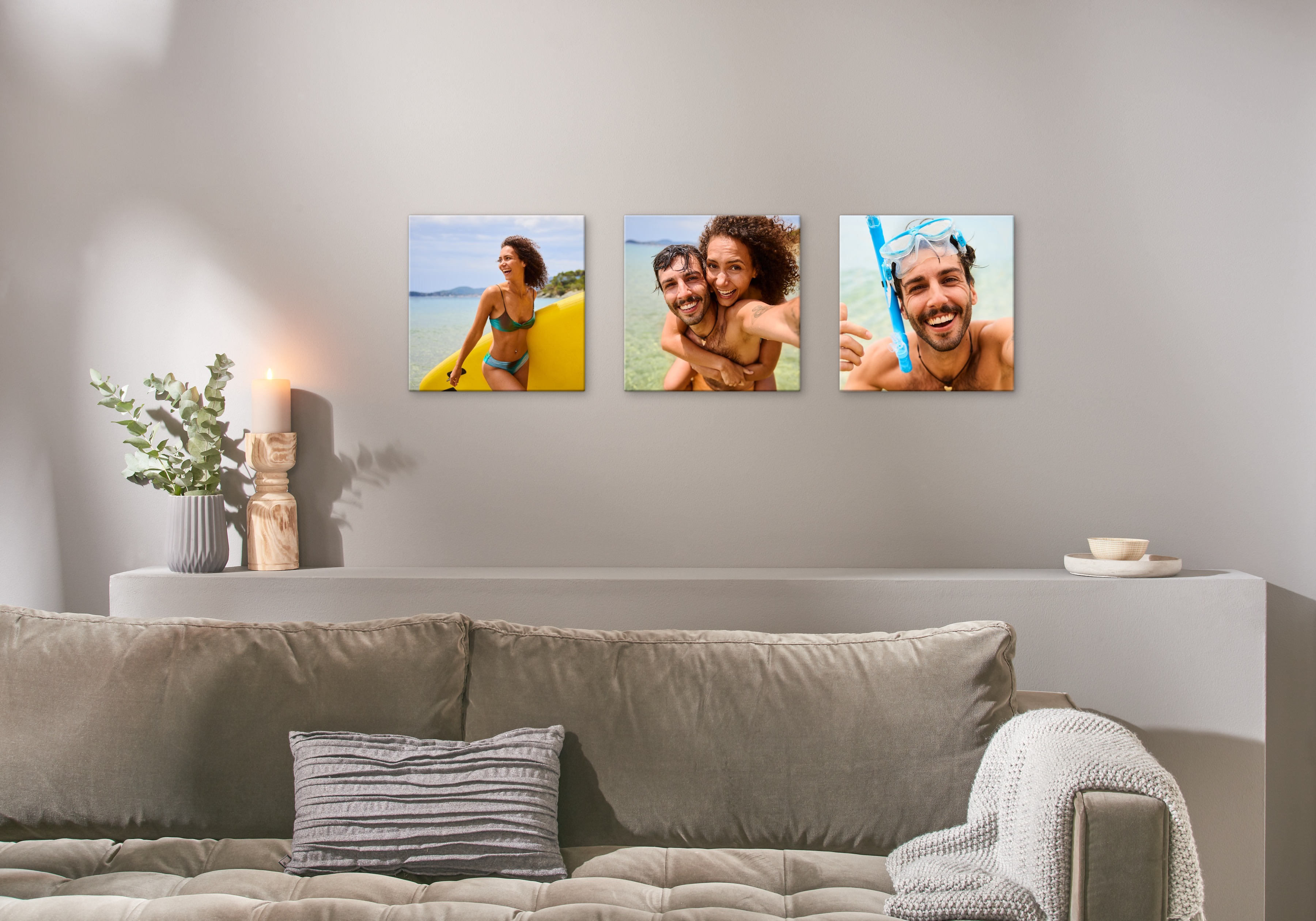 Drei Fotoleinwände hängen an einer Wand und zeigen Bilder von einem glücklichen Pärchen am Strand.