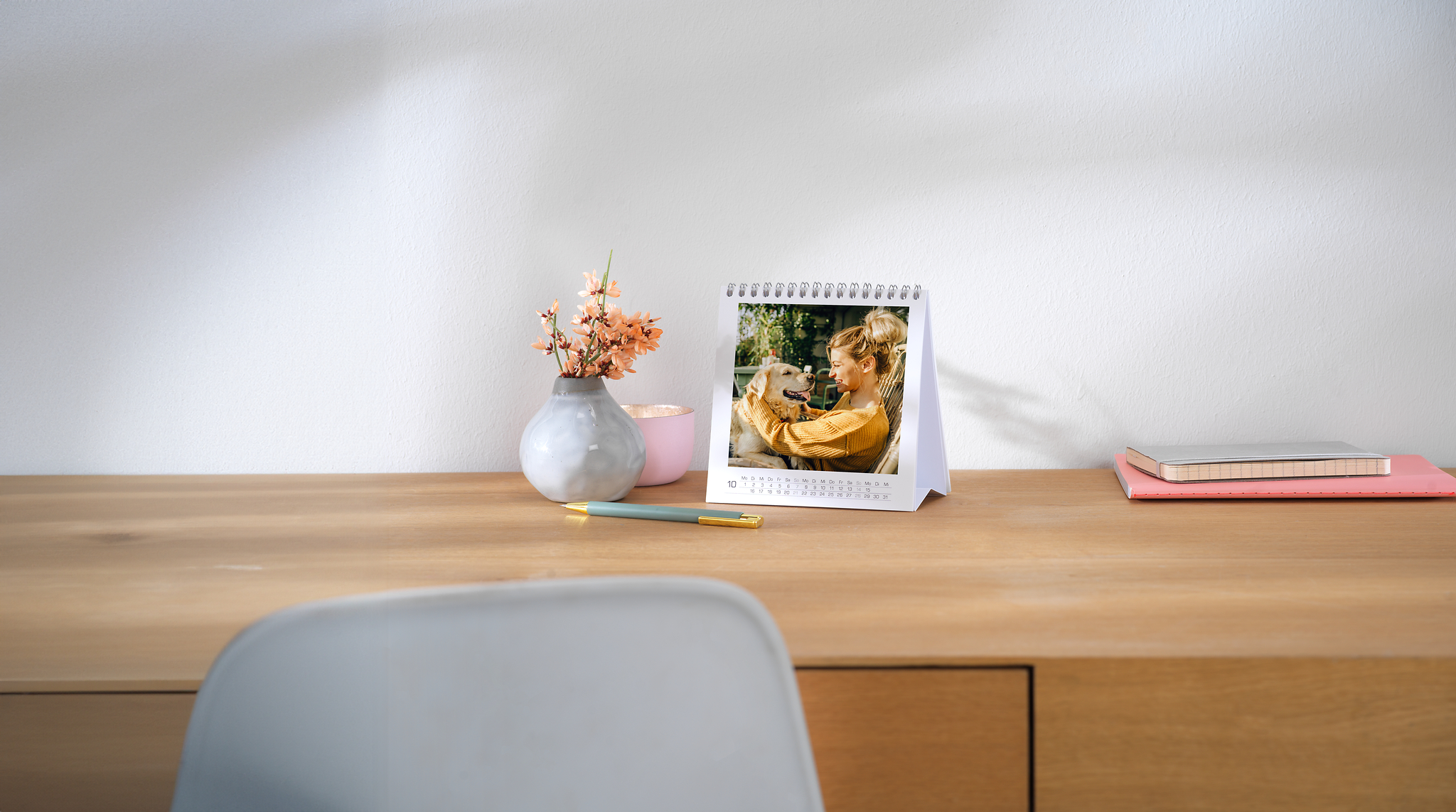 Bureaukalender met een foto van een vrouw en een hond op houten tafel