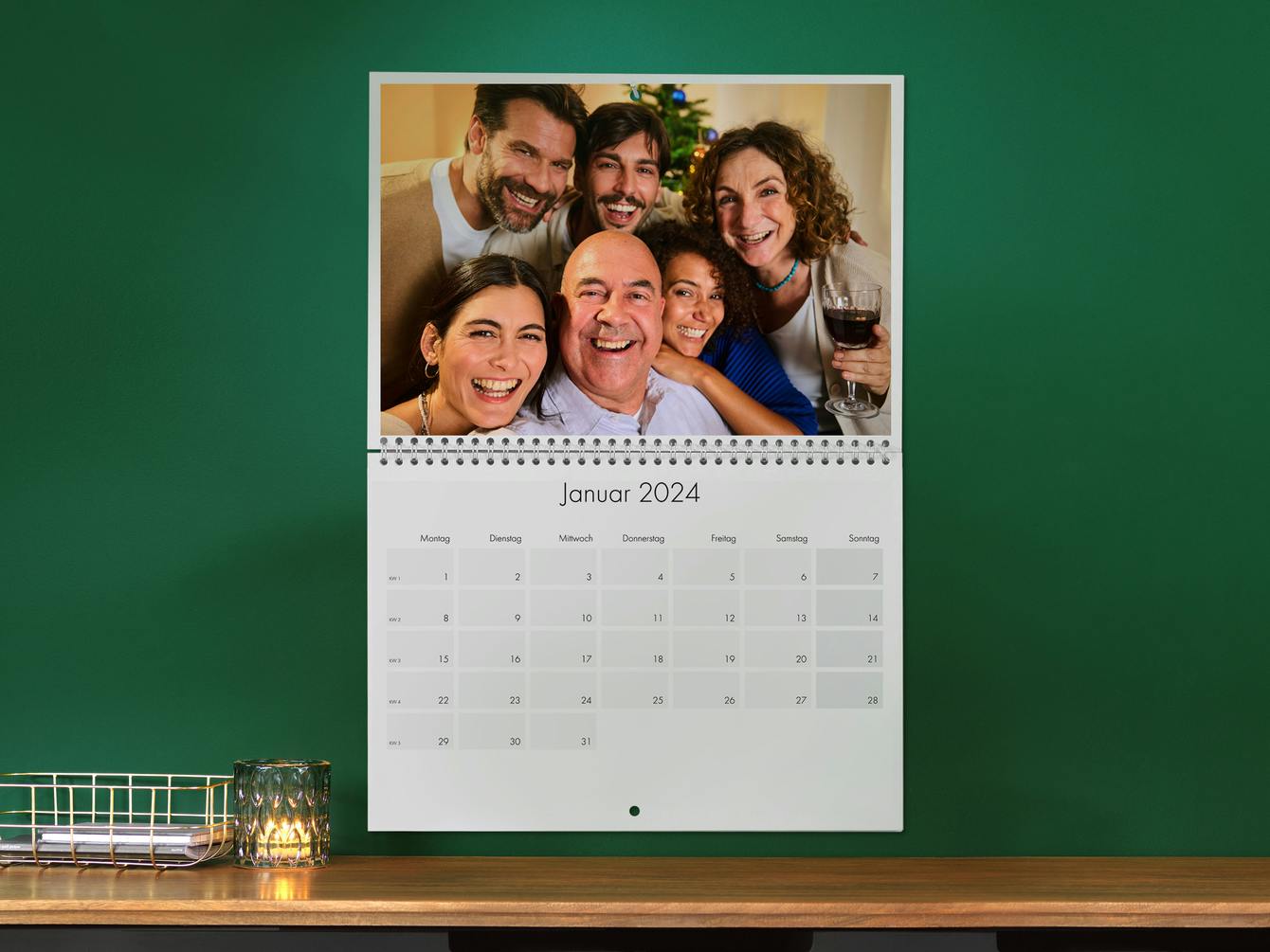 Pixum Fotokalender Klappkalender A3 mit einem Landschaftsmotiv an einer grünen Wand
