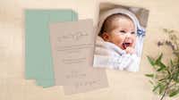 Pixum Fotogrußkarte zur Geburt im 10er Set Fotokarten mit Babyfoto und Text zur Geburt liegen gestapelt auf einem Tisch